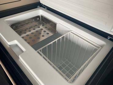 Preview: Mercedes Marco Polo Kühlschrankregal aus Edelstahl Preview: Mercedes Marco Polo Kühlschrank mit installiertem glänzenden Edelstahlregal, gefüllt mit Lebensmitteln und Getränken.