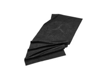 Schwarzes Strandtuch aus 100 % Baumwolle mit einer ca. 60 cm großen Hoch/Tief-Einwebung des historischen Mercedes-Benz Sterns, gefaltet dargestellt.