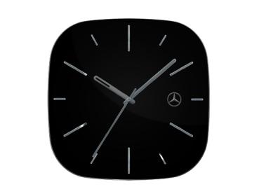 Schwarze Wanduhr mit quadratischem, abgerundeten Design, silberfarbenen Zeigern und minimalistischen Indexen. Das Mercedes-Benz Logo ist dezent im oberen rechten Bereich des Zifferblatts integriert.