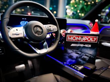Das Mercedes-AMG Monopoly im Innenraum eines Mercedes-Fahrzeugs, platziert auf der Mittelkonsole, umgeben von luxuriöser Ausstattung.