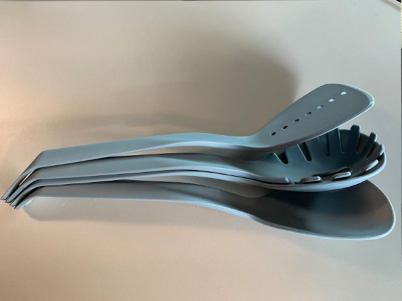 Das saubere und trockene Küchenhelfer-Set ist auf der Arbeitsfläche einer Wohnmobilküche arrangiert. Die spülmaschinengeeigneten Utensilien glänzen im Licht der Küchenbeleuchtung, bereit für den nächsten Einsatz. Dieses Bild zeigt, wie gut sich das Set au
