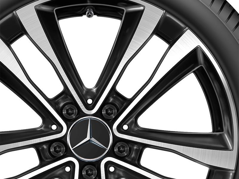Detailaufnahme einer Mercedes-Benz Leichtmetallfelge, die das filigrane Design der schwarz-silbernen Speichen und den markanten Mercedes-Stern im Zentrum zeigt. Detailaufnahme einer Mercedes-Benz Leichtmetallfelge, die das filigrane Design der schwarz-silbernen Speichen und den markanten Mercedes-Stern im Zentrum zeigt.