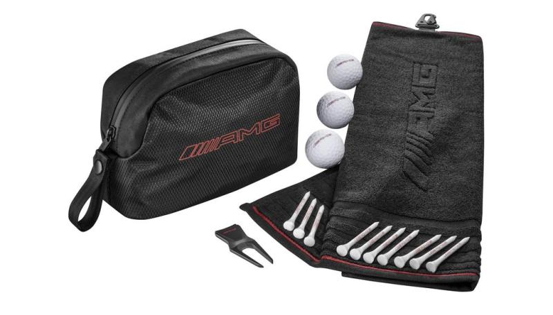 AMG Golf-Geschenkset bestehend aus schwarzer Tasche, Schlägerhandtuch, Golfbällen, Tees und Pitchgabel, präsentiert auf einem weißen Hintergrund.