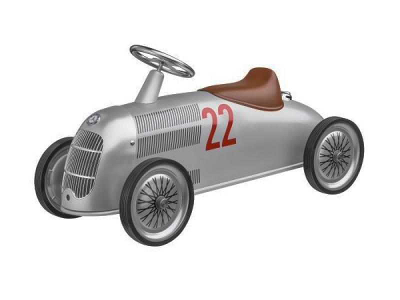 Kinderrutscher im Stil des klassischen Mercedes-Benz Silberpfeils, Modell W 25, in silberfarbenem Design mit brauner Kunstleder-Sitzfläche, PVC-Rädern und roten Rennsportdetails.