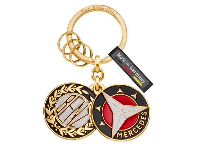 Vergoldeter Schlüsselanhänger mit zwei Logoplaketten: Benz-Markenzeichen von 1909 und Mercedes-Markenzeichen von 1916, inklusive drei Minispaltringen.
