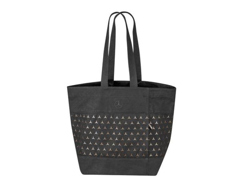 Schwarze Mercedes-Benz Einkaufstasche mit zweifarbigem Muster aus kleinen dreieckigen Symbolen, die die klassische Mercedes-Benz Dreizack-Symbolik zeigen. Die Tasche hat zwei lange Henkel, die es einfach machen, sie über der Schulter zu tragen.