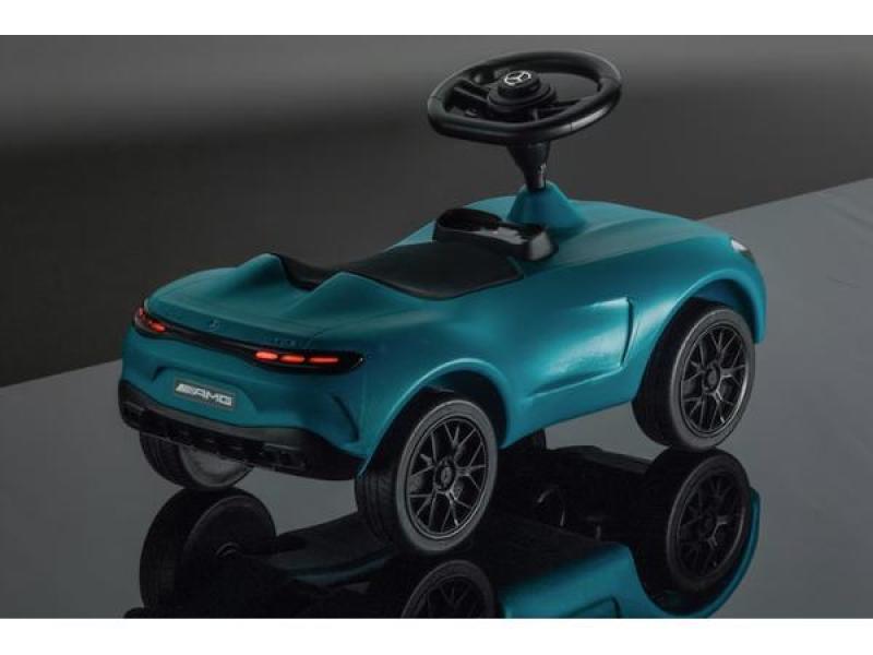 Heckansicht eines türkisen Mercedes-AMG GT Rutschfahrzeugs, mit leuchtenden Rücklichtern, schwarzen AMG-Felgen und detailliertem sportlichem Design auf einer spiegelnden Oberfläche