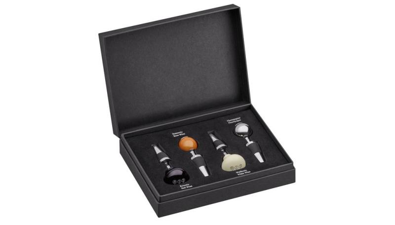 Geöffnetes Weinverschluss-Set in edler Schaltknaufoptik mit vier hochwertigen Verschlüssen in einer eleganten schwarzen Box. Die Verschlüsse sind in Rot, Weiß und Silberfarben gestaltet.