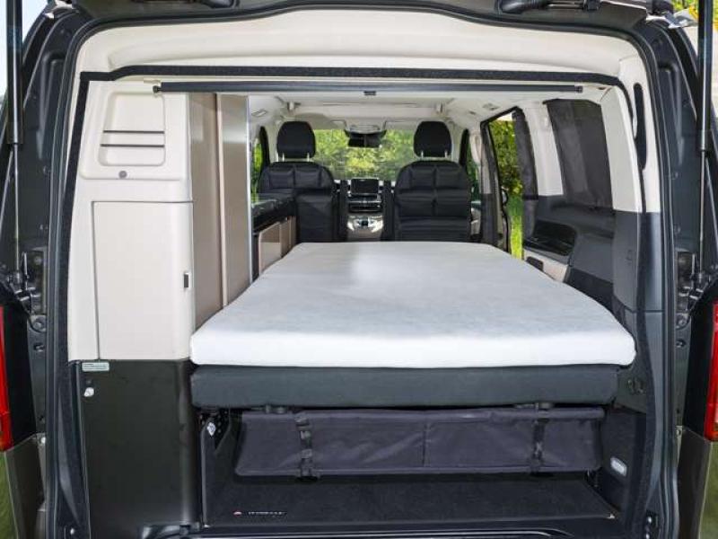 Ein luxuriöses iXTEND Faltbett in einem Mercedes-Benz V-Klasse Marco Polo, perfekt bedeckt mit dem BRANDRUP iXTEND Spannbettlaken in einem sanften Grauton