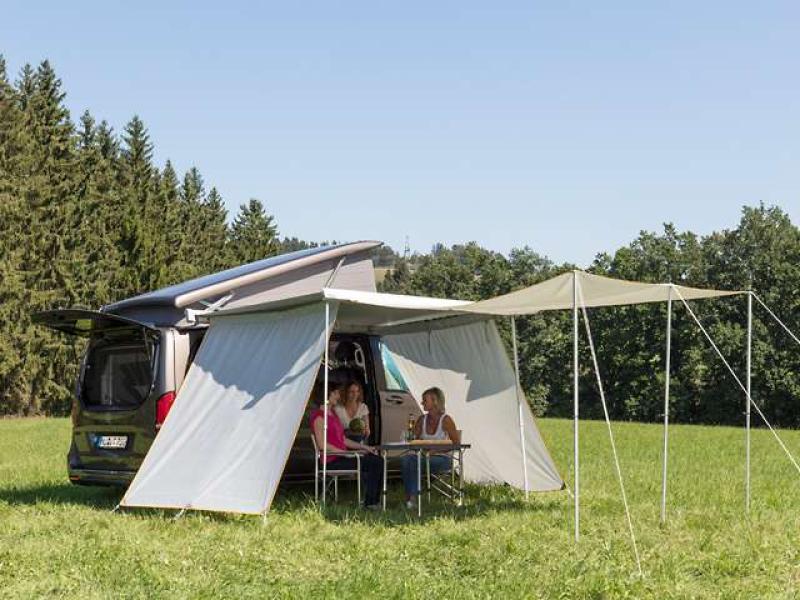 Hände befestigen die Rollmarkisen-Vorderwand mit einem Spezialkeder an der Aluschiene eines Mercedes-Benz Marco Polo.